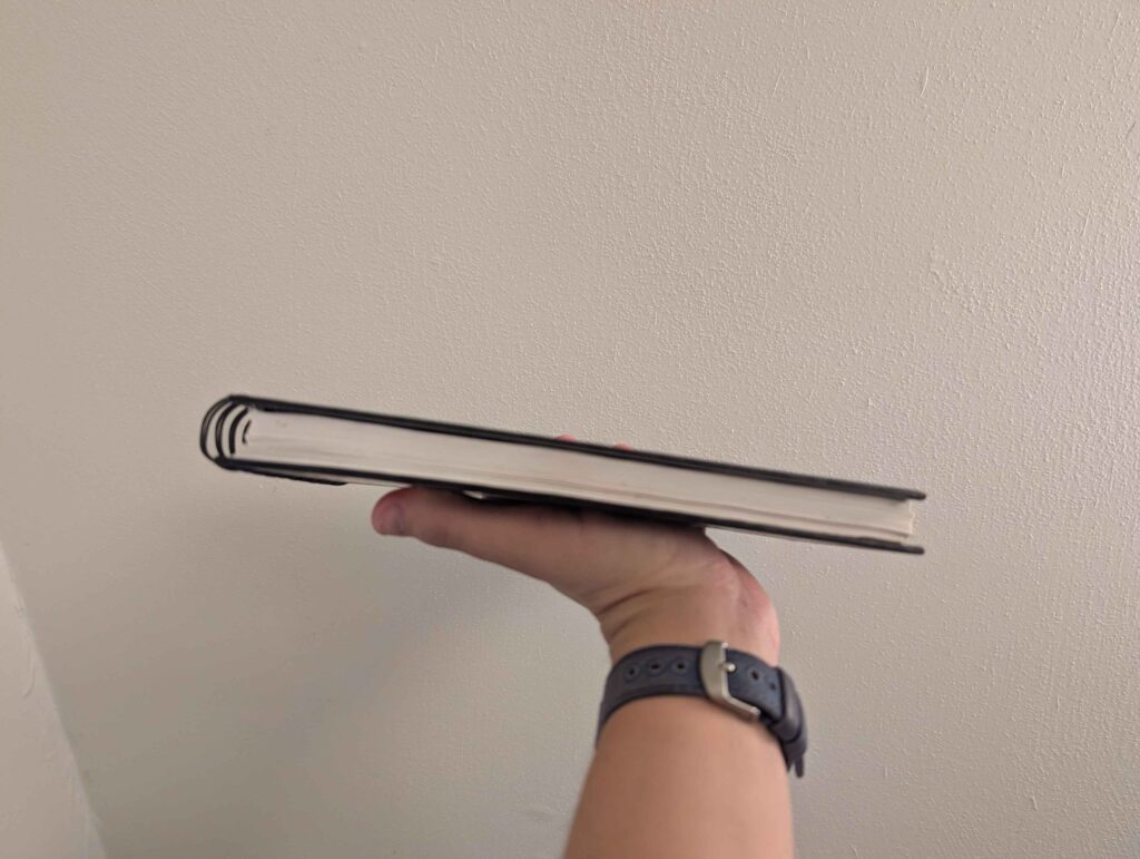A side view of an art notebook with clean, white pages.